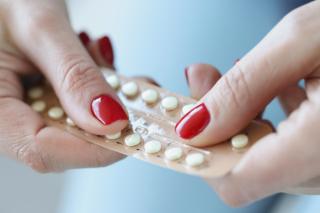 Tablette de pilules contraceptives entre les mains d'une femme